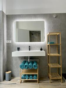 a bathroom with a sink and a mirror and towels at MARAIS Appartement 2 Chambres 2 Salles de bain - SPA JACUZZI ! in Paris