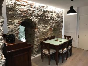 a dining room with a table and a stone wall at Alojamiento Wadi Dar Al-Farah II "La Casa de la Alegría de Guadix" in Guadix