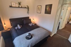 Schlafzimmer mit einem Bett mit blauer Decke in der Unterkunft An Idyllic Essex Escape in Witham
