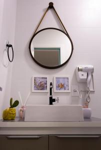 La salle de bains est pourvue d'un lavabo blanc et d'un miroir. dans l'établissement Ap Studio Praia Campeche, à Florianópolis