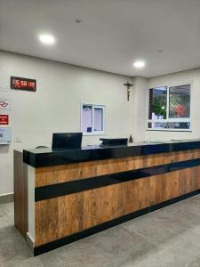 a lobby with a desk with a clock on the wall at Hotel Guarumar Gold in Guarujá