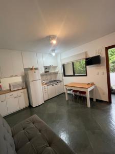 a small kitchen with a table and a refrigerator at Piemonte Flat Serra Neg SP in Serra Negra