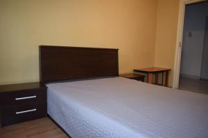 a bedroom with a large bed with a wooden headboard at Apartament Modest Traian RHBM in Baia Mare