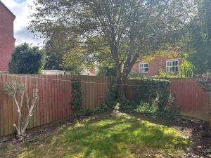 una cerca en un patio con un árbol detrás de ella en The Town House, whole house suitable for contractors and families, en Market Harborough