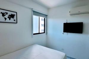 um quarto branco com uma cama e uma janela em Melhor localização em Boa Viagem! em Recife