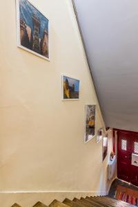 un pasillo con fotos en la pared de un edificio en Apartamento com escada e pátio, em frente praia en Paço de Arcos