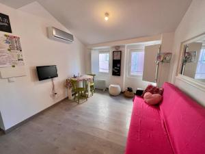 sala de estar con sofá rosa y mesa en Apartamento com escada e pátio, em frente praia en Paço de Arcos