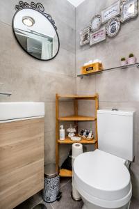a bathroom with a white toilet and a mirror at Apartamento com escada e pátio, em frente praia in Paço de Arcos