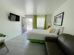 a bedroom with a bed and a couch and a television at Loma Linda Inn in San Bernardino