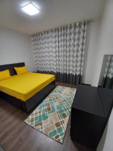 - une chambre avec un lit jaune et un tapis dans l'établissement شقه في ارقي كمبوند الشيخ زايد, à Sheikh Zayed