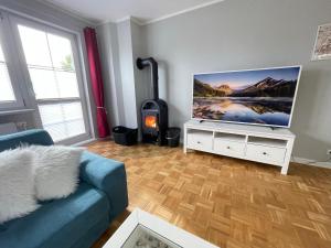 a living room with a blue couch and a flat screen tv at Wohlfuehl-Orte24 am Hafen in Schaprode, Rügen in Schaprode