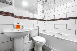 een witte badkamer met een toilet en een wastafel bij Beautiful 2 Bedroom Apartment MK Free Parking in Woolstone