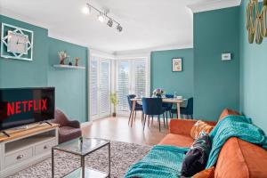 een woonkamer met blauwe muren en een bank bij Beautiful 2 Bedroom Apartment MK Free Parking in Woolstone