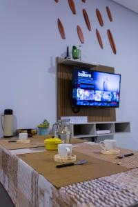 - une table avec deux tasses et une télévision dans la chambre dans l'établissement Ap Studio Praia Campeche, à Florianópolis