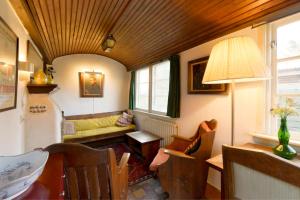 salon z kanapą i stołem w obiekcie Rustic Retreat: Fireplace, BBQ, + Forest Access w mieście Burgh Haamstede