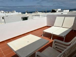 a balcony with a table and chairs on a roof at La charquita in Famara