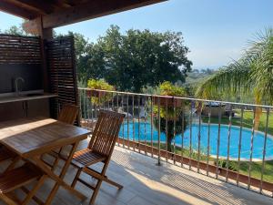 a balcony with a table and chairs and a swimming pool at Casale Calabria in Gizzeria
