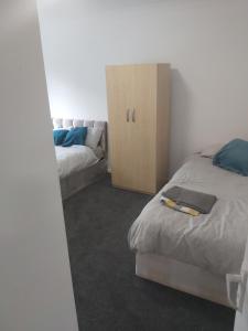 a bedroom with two beds and a dresser at super comfortable 3 bed house in Houghton Regis