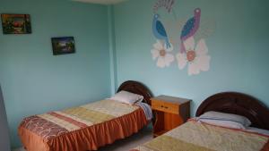 a bedroom with two beds and a blue wall at Zumag Sisa in Tena