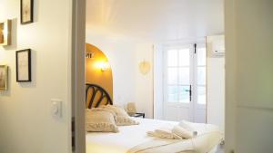 a bedroom with a bed with white sheets at Wistéria - Piscine - Le Pré Pommier - BY PRIMO C0NCIERGERIE in Azé
