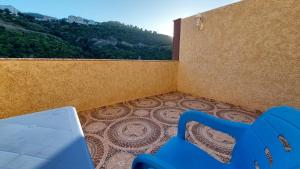 Hotel Blador في Tichi: كرسي ازرق في غرفة مطلة