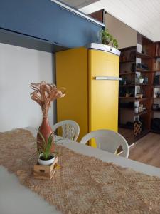 a dining room with a table and a yellow cabinet at Casa América in Parnaíba