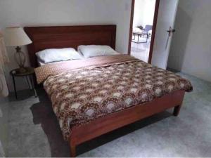 a bedroom with a large bed with a wooden headboard at Modern Tropical Home in Atabay