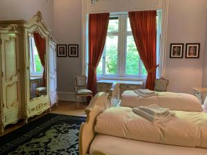 a bedroom with two beds and a mirror at Schloss Langenzell, Grafensuite in Wiesenbach