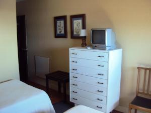 a bedroom with a dresser with a tv on it at Residencial do Mar in Praia de Mira