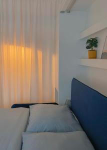 sypialnia z łóżkiem i oknem z rośliną w obiekcie NØDA - Nørdic Design Apartment with Terrace w Liptowskim Mikulaszu