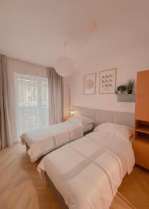 dwa łóżka w pokoju z oknem w obiekcie NØDA - Nørdic Design Apartment with Terrace w Liptowskim Mikulaszu
