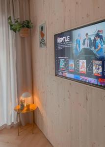 telewizor z płaskim ekranem wiszący na ścianie ze stołem w obiekcie NØDA - Nørdic Design Apartment with Terrace w Liptowskim Mikulaszu