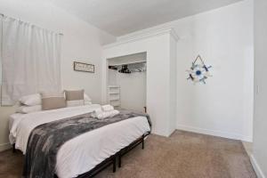 twee bedden in een kamer met witte muren bij Detached guesthouse in Belmont Heights in Long Beach