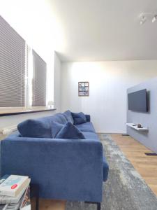 a living room with a blue couch and a tv at 'BRIGHT 201' Moderne, helle Wohnung in BI Zentrum, 400 m bis Lokschuppen, Smart-TV, WLAN in Bielefeld