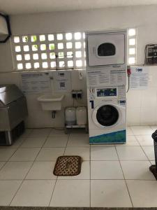lavadero con lavadora y fregadero en Village amplo e aconchegante! Solaris Imbassaí en Mata de Sao Joao