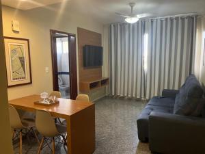 a living room with a blue couch and a table at Apto setor central 808 in Goiânia