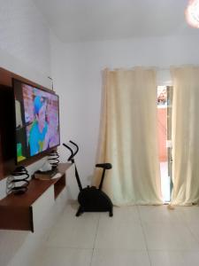 een woonkamer met een flatscreen-tv en een stofzuiger bij Cantinho da paz in Cabo Frio