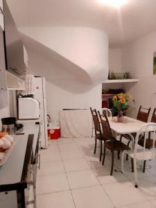 een keuken met een tafel en een aantal stoelen en een tafel en een keuken bij Cantinho da paz in Cabo Frio