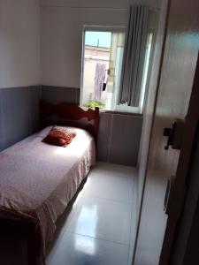 een kleine slaapkamer met een bed en een raam bij Cantinho da paz in Cabo Frio