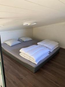 a bed in a room with two pillows on it at Stuga på ö / närhet till vatten in Mariestad
