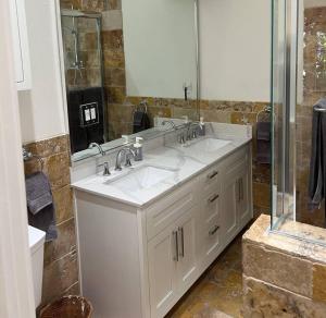 a bathroom with two sinks and a large mirror at laguna beach cottage home in Laguna Beach +51 photos