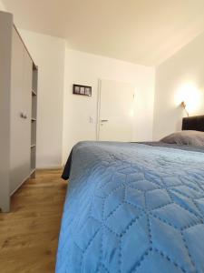 a bedroom with a blue quilt on a bed at 'BRIGHT 201' Moderne, helle Wohnung in BI Zentrum, 400 m bis Lokschuppen, Smart-TV, WLAN in Bielefeld