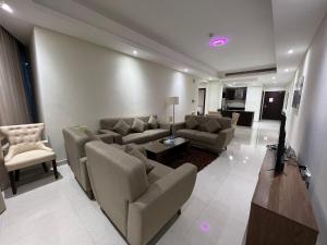 a living room with couches and a couch and a table at SIRIUS TOWER in Juffair