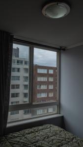 a bedroom window with a view of a building at Habitaciones en Departamento compartido centro de Viña in Viña del Mar