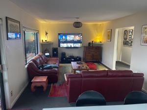a living room with two couches and a tv at Kaiapoi Village House in Kaiapoi