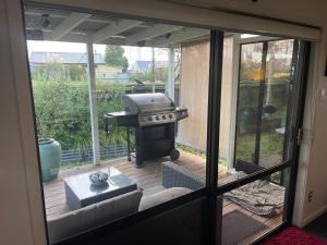 een uitzicht op een patio met een grill in een huis bij Kaiapoi Village House in Kaiapoi