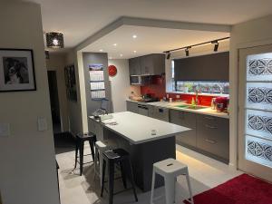 a kitchen with a counter and stools in it at Kaiapoi Village House in Kaiapoi