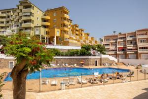 a swimming pool in a resort with buildings in the background at Great Ocean View Torviscas Beach Home by LoveTenerife in Adeje