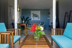 un jarrón de flores sobre una mesa de madera en la sala de estar en Diver's Paradise Bonaire, en Kralendijk