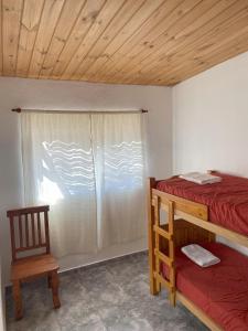 a bedroom with two bunk beds and a window at Cabañas Llitulun in Alpa Corral